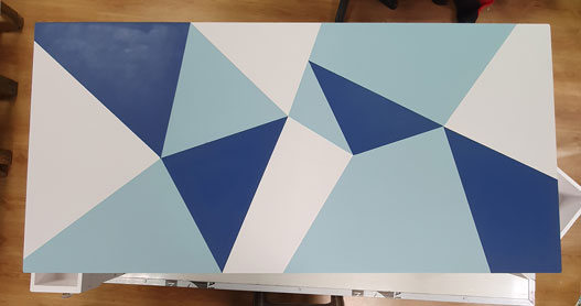 Formes géométriques réalisées sur le plateau d'une table basse pour la relooker.