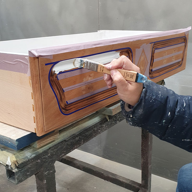 application de la sous-couche sur le tiroir d'une commode ancienne